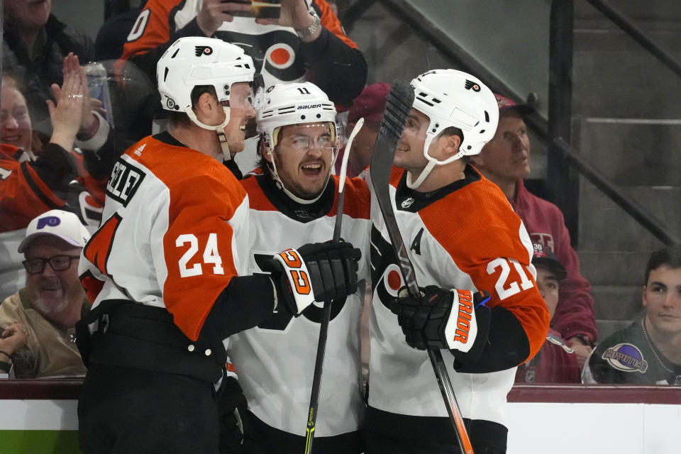 Philadelphia Flyers right wing Travis Konecny (11) celebrates after his goal against the Arizona Coyotes with Flyers defenseman Nick Seeler (24) and center Scott Laughton (21) during the second period of an NHL hockey game Thursday, Dec. 7, 2023, in Tempe, Ariz. (AP Photo/Ross D. Franklin)