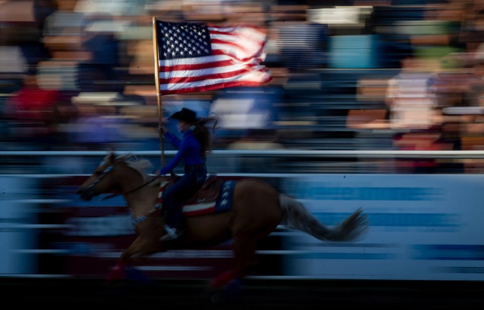 Aviah Woods,12, carries the American flag atop her horse Annie during the opening night of the 2022 Eugene Pro Rodeo.