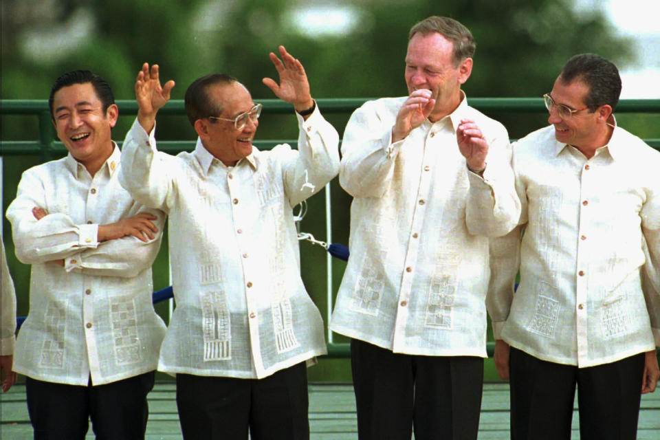 FILE - Philippine President Fidel Ramos, second left, urges other presidents to wave with hands during a brief photo session prior to the summit of APEC leaders in Subic, west of Manila, on Nov. 25, 1996. From left are Japanese Prime Minister Ryutaro Hashimoto, President Ramos, Canadian Prime Minister Jean Chretien and Mexican President Ernesto Zedillo. Ramos, a U.S.-trained ex-general who saw action in the Korean and Vietnam wars and played a key role in a 1986 pro-democracy uprising that ousted a dictator, has died. He was 94. Some of Ramos's relatives were with him when he died on Sunday, July 31, 2022, said his longtime aide Norman Legaspi. (AP Photo/Fred Chartrand, File)