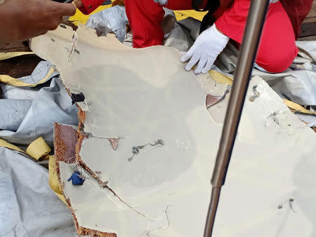 Workers of PT Pertamina examine recovered debris of what is believed from the crashed Lion Air flight JT610, onboard Prabu ship owned by PT Pertamina, off the shore of Karawang regency, West Java province, Indonesia, October 29, 2018. Antara Foto/PT Pertamina/Handout via REUTERS