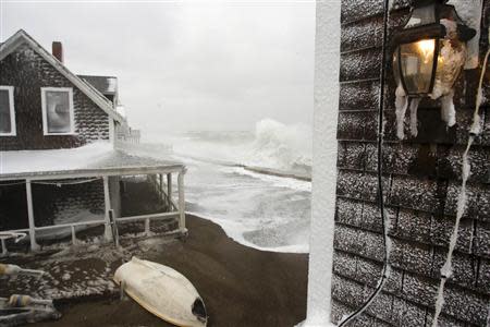 Waves crash into houses on Lighthouse Road during a winter nor'easter snow storm in Scituate, Massachusetts January 3, 2014. REUTERS/Dominick Reuter