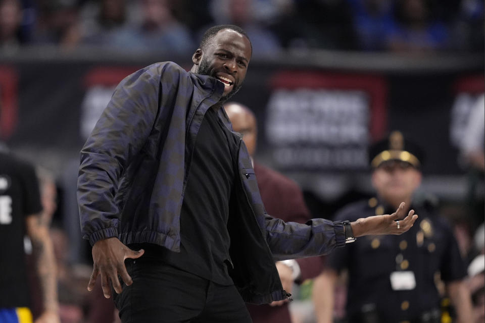 Golden State Warriors' Draymond Green gestures as he speaks to an official during a timeout in the second half of the team's NBA basketball game against the Dallas Mavericks in Dallas, Wednesday, March 13, 2024. Green did not play in the game. (AP Photo/Tony Gutierrez)