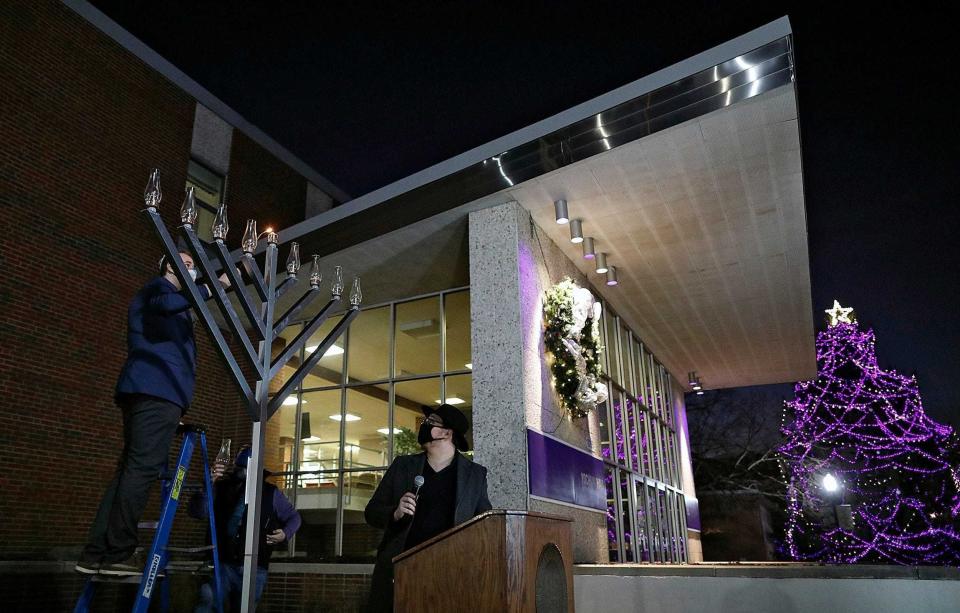 Gareth Evans, a Jewish student representative and senior at Capital University, lights the shammash during a menorah lighting ceremony at the Bexley university in December. The shammash is the candle used to light the others in a Hanukkah menorah.