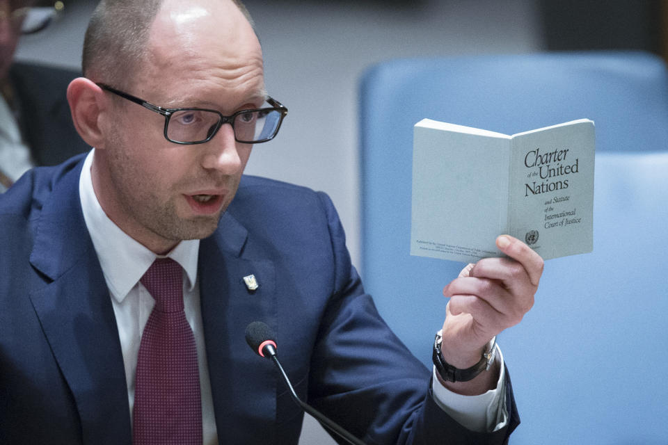 Ukrainian interim Prime Minister Arseniy Yatsenyuk speaks as he holds a copy of the United Nations charter during an U.N. Security Council meeting on the Ukraine crisis, Thursday, March 13, 2014, at the United Nations Headquarters. Yatsenyuk, during a meeting with President Barack Obama on Wednesday, declared in English that his government was "absolutely ready and open for talks with the Russian Federation" and urged Moscow to "start the dialogue" without guns and tanks. (AP Photo/John Minchillo)