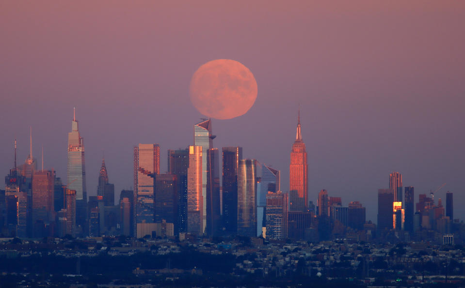 The moon rises behind the midtown Manhattan skyline on September 19, 2021, as seen from West Orange, New Jersey. The full moon closest to the autumnal equinox is known as the Harvest Moon. / Credit: Gary Hershorn / Getty Images