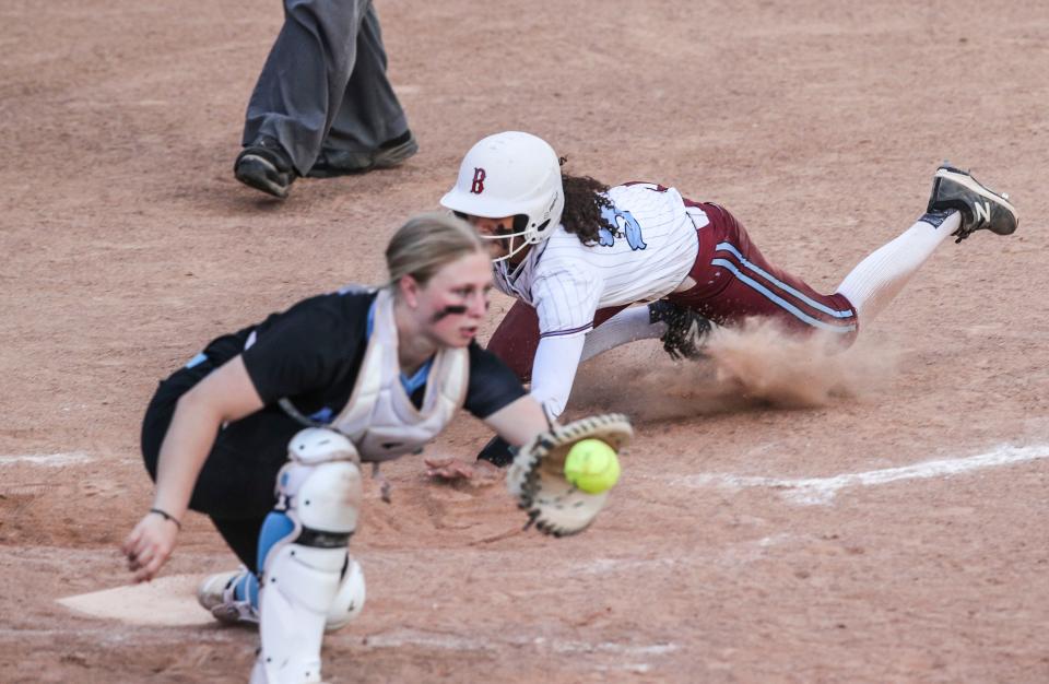 Ballard's Mikayla Milby escapes the tag by Mercy catcher Peyton Arnold. Arnold batted .413 last season.