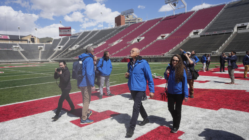 FILE - Karl Stoss, center, chairman of the International Olympic Committee's Future Host Commission, walks across the football field at Rice-Eccles Stadium on the campus of University of Utah, Wednesday, April 10, 2024, in Salt Lake City. Organizers of the Salt Lake City Olympic committee will reveal on Monday, June 10, 2024, the estimated budget for hosting the 2034 Winter Olympics. (AP Photo/Rick Bowmer, File)