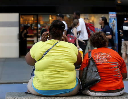 Women sit on a bench in New York's Times Square in this May 31, 2012 file photo. REUTERS/Brendan McDermid/Files