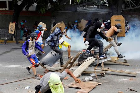 Demonstrators run away at a rally against Venezuelan President Nicolas Maduro's government in Caracas. REUTERS/Carlos Garcia Rawlins