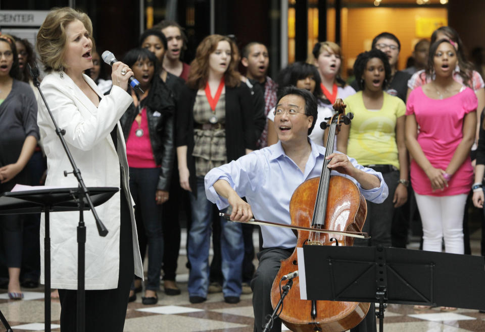 World-famous cellist Yo-Yo Ma and famed soprano Renee Fleming, left, perform with a choir of dozens of high school students in the rotunda of the State of Illinois building, the James R. Thompson Center, Monday, March 19, 2012, in Chicago. The Monday afternoon performance was to promote the Chicago Symphony Orchestra's Citizen Musician initiative. The Lyric Opera of Chicago also sponsored the event and Illinois Gov. Pat Quinn attended. (AP Photo/Kiichiro Sato)