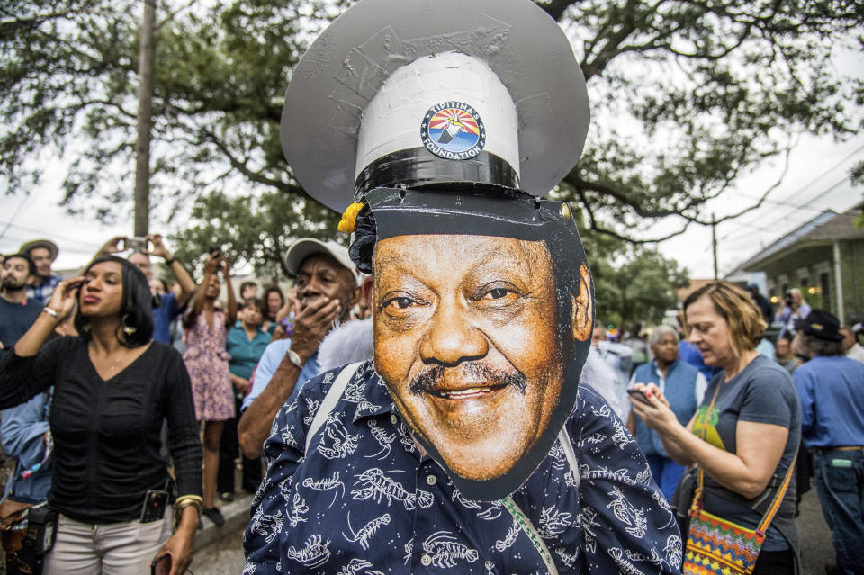 FILE - Fans parade down Poland Avenue toward the former home of music legend Antoine 'Fats' Domino during a second line parade honoring him on Nov. 1, 2017, in New Orleans. The New Orleans street where Domino, one of the founders of rock ‘n’ roll spent most of his life, is being renamed in his honor. (Photo by Amy Harris/Invision/AP, File)