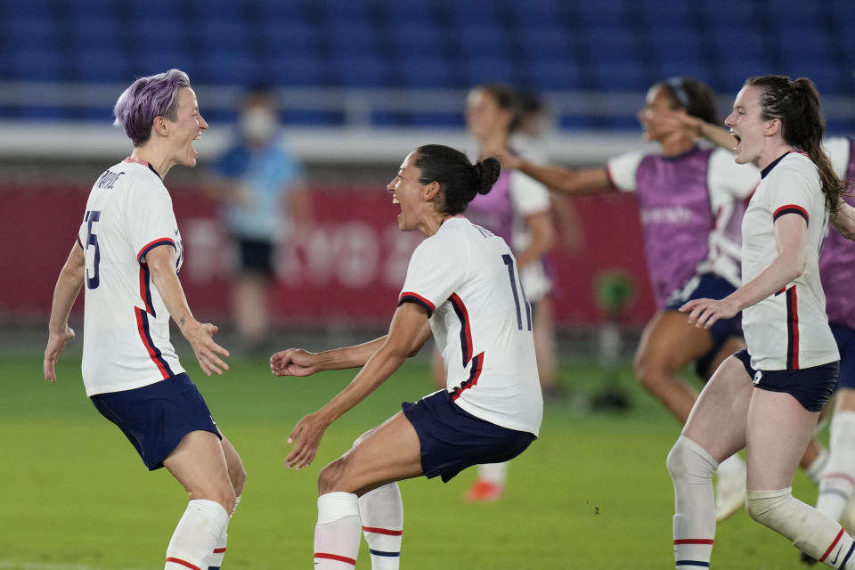 United States' Megan Rapinoe, left, celebrates with teammates after scoring the winning goal and defeating the Netherlands in a penalty shootout during a women's quarterfinal soccer match at the 2020 Summer Olympics, Friday, July 30, 2021, in Yokohama, Japan. (AP Photo/Silvia Izquierdo)