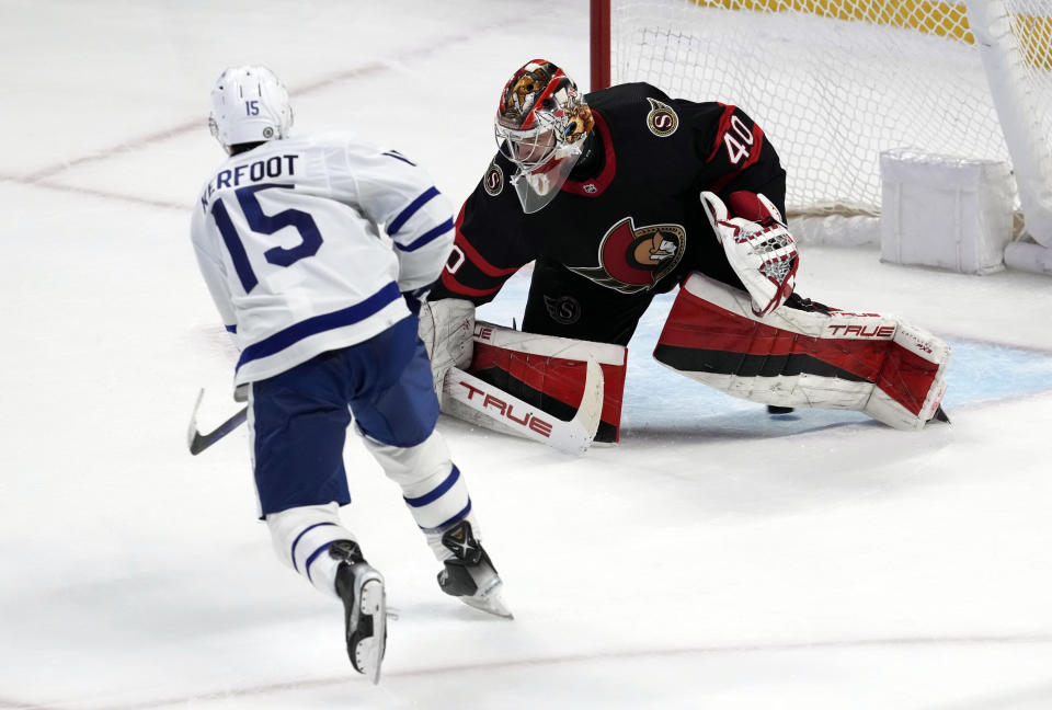 Toronto Maple Leafs center Alexander Kerfoot slips the puck under Ottawa Senators goaltender Mads Sogaard during shootout NHL hockey game action in Ottawa, Ontario, Saturday, March 18, 2023. (Adrian Wyld/The Canadian Press via AP)