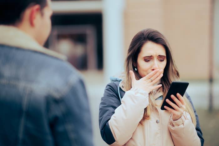 a woman shocked at something she's seeing on her phone