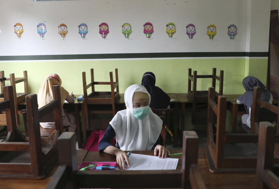 Students wearing face masks sit spaced apart during a trial run of a class with COVID-19 protocol at Nurul Amal Islamic school in Tangerang, Indonesia, Monday, Nov. 23, 2020. (AP Photo/Tatan Syuflana)