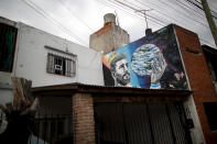 A mural depicting Lionel Messi wearing a crown and holding an orb portraying planet earth decorates a wall in the neighborhood of his hometown La Bajada, Argentina, Thursday, Aug. 27, 2020. Fans of Newell's Old Boys hope to lure him home following his announcement that he wants to leave Barcelona F.C. after nearly two decades with the Spanish club. (AP Photo/Natacha Pisarenko)