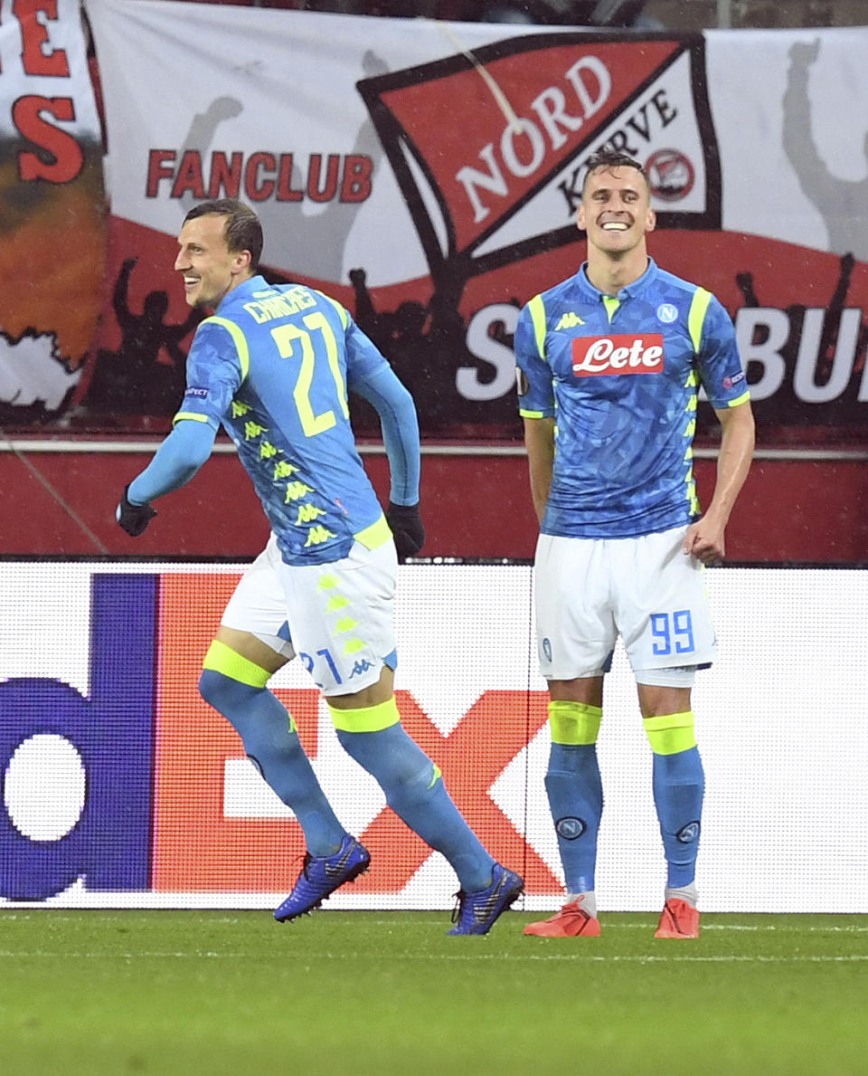 Napoli's Arkadiusz Milik, ight, celebrates with Napoli's Vlad Chiricheş after scoring his side's first goal during the Europa League round of 16 second leg soccer match between FC Salzburg and Napoli in the Arena stadium in Salzburg, Austria, Thursday, March 14, 2019. (AP Photo/Kerstin Joensson)