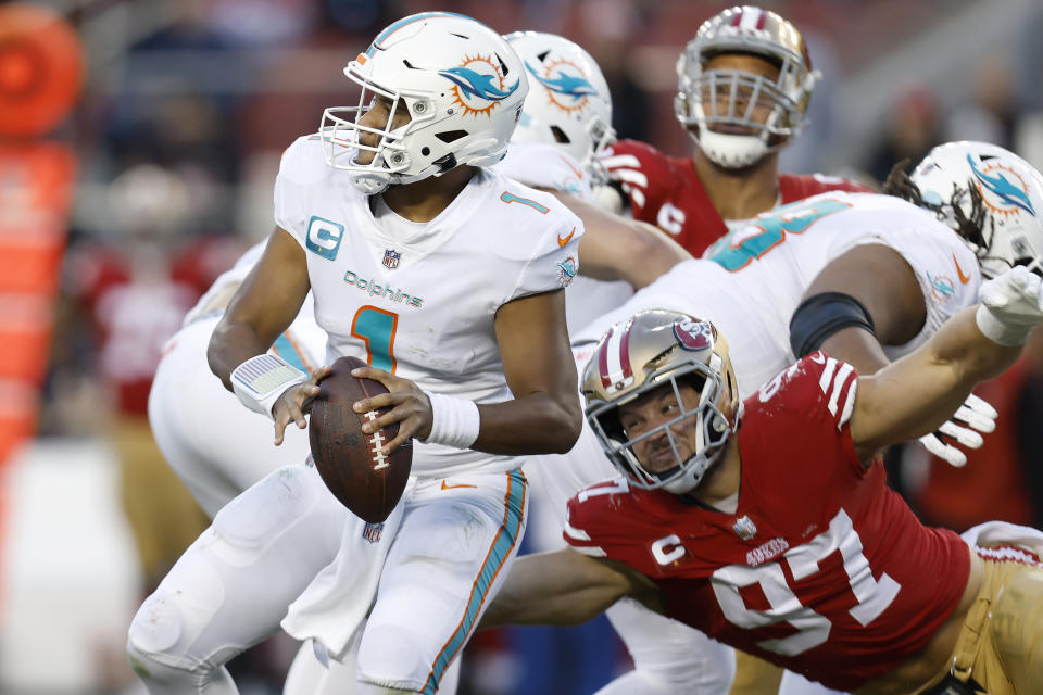 Miami Dolphins quarterback Tua Tagovailoa (1) looks to pass before San Francisco 49ers defensive end Nick Bosa (97) caused Tagovailoa to fumble, which 49ers linebacker Dre Greenlaw returned for a touchdown, during the second half of an NFL football game in Santa Clara, Calif., Sunday, Dec. 4, 2022. (AP Photo/Jed Jacobsohn)