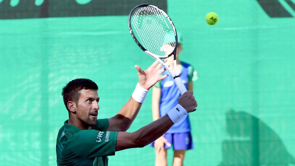 Serbian tennis player Novak Djokovic returns the ball during an exhibition match, organized to mark the opening of a tennis court at the 
