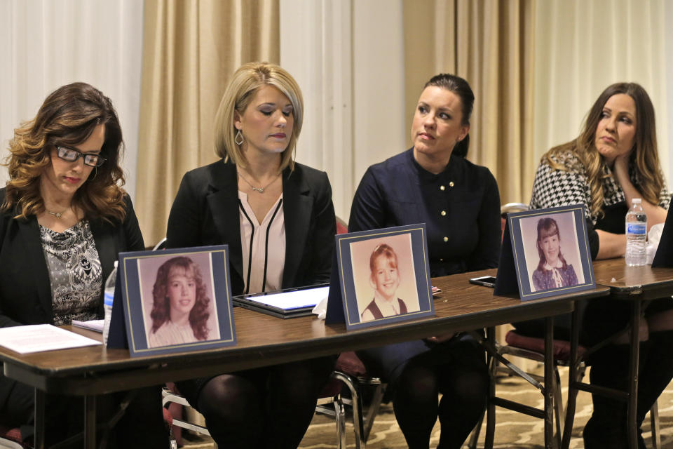 Sisters Patty Fortney-Julius, Lara Fortney McKeever, second from left, Teresa Forteny-Miller, second from right, and Carolyn Fortney sit behind pictures of themselves as children as they listen to an attorney speak to reporters during a news conference in Newark, N.J., Monday, Dec. 2, 2019. Two of the sisters from Pennsylvania, Patty and Lara, are suing the Archdiocese of Newark and the Diocese of Harrisburg, Pennsylvania. They allege clergy in Newark knew a priest had sexually abused children before he moved to Harrisburg and abused them and their sisters for years. Lawsuits alleging sexual abuse by Roman Catholic clergy are taking center stage in New Jersey as the state's relaxation of statute of limitations rules takes effect. (AP Photo/Seth Wenig)