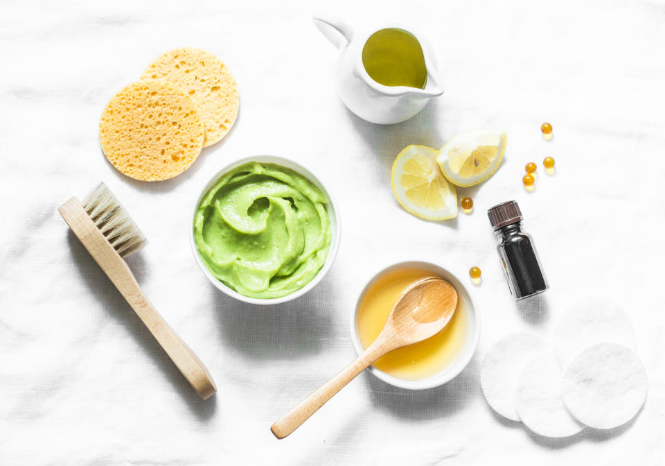 Honey and avocado face mask on light background, top view. Beauty, youth, skin care concept. Flat lay