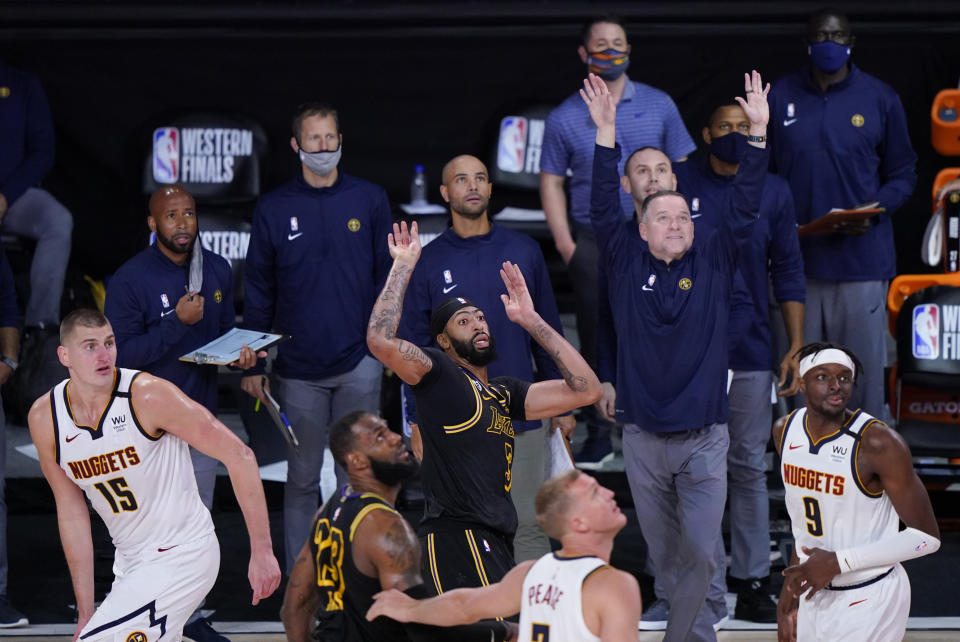 Los Angeles Lakers' Anthony Davis (3) watches his last second 3-point basket between Denver Nuggets' Nikola Jokic (15) and Jerami Grant (9) in an NBA conference final playoff basketball game Sunday, Sept. 20, 2020, in Lake Buena Vista, Fla. The Lakers won 105-103. (AP Photo/Mark J. Terrill)