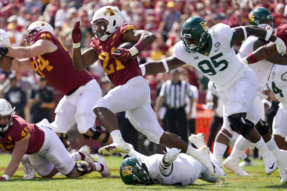 Iowa State running back Jirehl Brock (21) runs from Baylor defensive lineman Gabe Hall (95) during the second half of an NCAA college football game, Saturday, Sept. 24, 2022, in Ames, Iowa. Baylor won 31-24. (AP Photo/Charlie Neibergall)