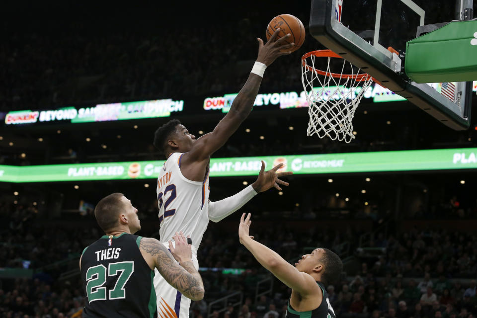 Phoenix Suns center Deandre Ayton (22) lays the ball up over Boston Celtics forward Daniel Theis (27) and forward Grant Williams (12) during the first half of an NBA basketball game, Saturday, Jan. 18, 2020, in Boston. (AP Photo/Mary Schwalm)