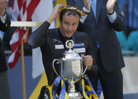 Marcel Hug of Switzerland accepts the first place trophy after winning men's wheelchair division of the 120th Boston Marathon in Boston, Massachusetts April 18, 2016. REUTERS/Brian Snyder