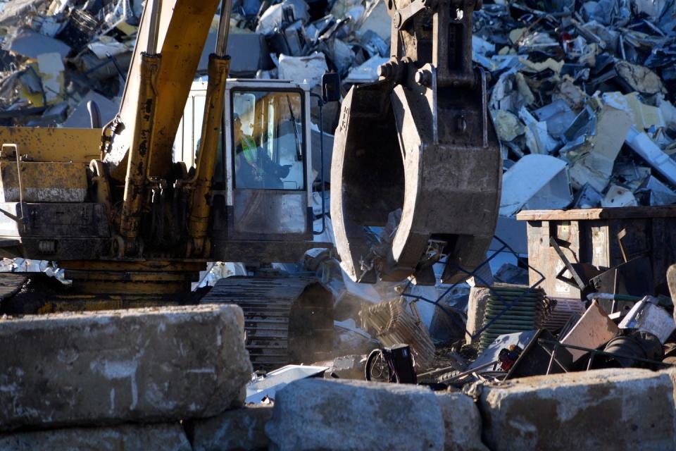 An excavator moves scrap metal around at Rhode Island Recycled Metals. A court-ordered investigation will determine whether actions by the current or former property owners caused hazardous substances to be released into the soil or water.