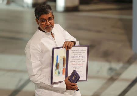 Nobel Peace Prize laureate Kailash Satyarthi holds the medal and the diploma during the Nobel Peace Prize awards ceremony at the City Hall in Oslo December 10, 2014. REUTERS/Suzanne Plunkett