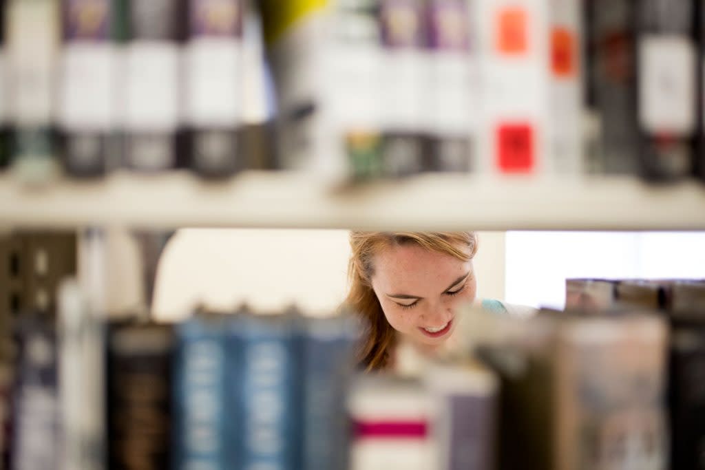 A woman looks through the book collection at a library.