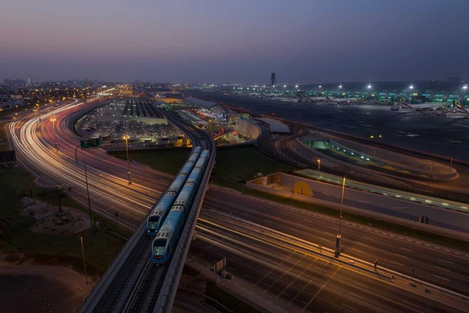 Dubai Airport, Dubai Metro trains and Highway at night