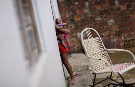 Gleyse Kelly da Silva holds her daughter Maria Giovanna, who has microcephaly, in their house in Recife, Brazil, January 30, 2016. Picture taken on January 30, 2016. REUTERS/Ueslei Marcelino