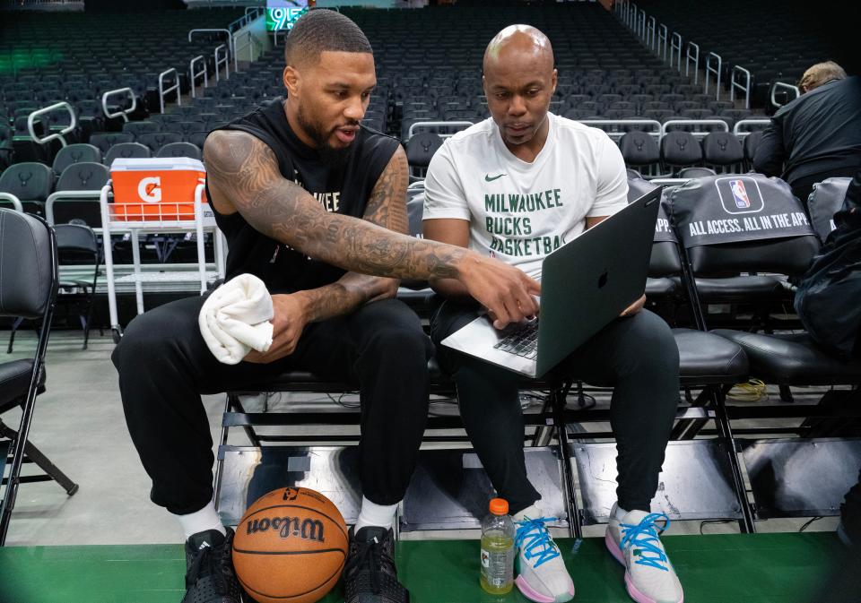 Damian Lillard, shown talking with assistant coach Nate Mitchell, knows he was brought to Milwaukee to help the Bucks win a title, and he's willing to sacrifice to do so.