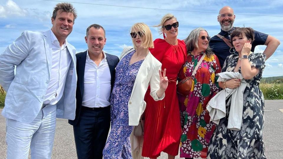 Zoe Ball with friends in a red wedding guest dress and sunglasses