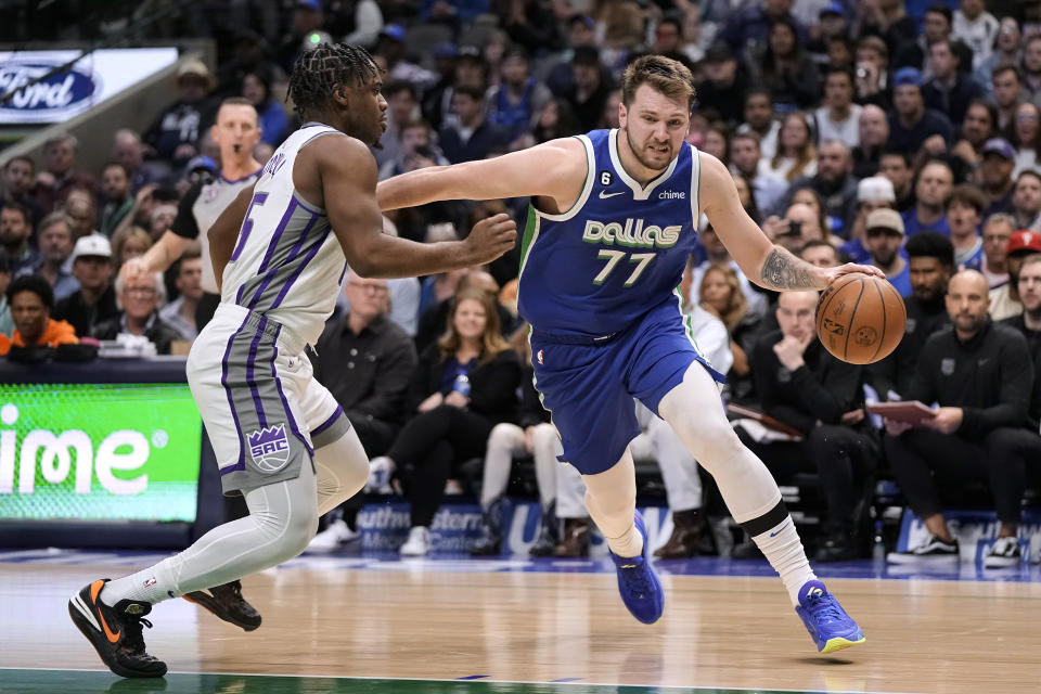 Dallas Mavericks guard Luka Doncic (77) drives the ball against Sacramento Kings guard Davion Mitchell (15) during the second half of an NBA basketball game in Dallas, Wednesday, April 5, 2023. (AP Photo/Sam Hodde)