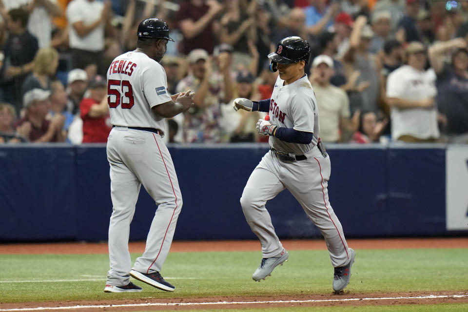 Boston Red Sox's Masataka Yoshida, of Japan, celebrates with third base coach Carlos Febles (53) after hitting a two-run home run off Tampa Bay Rays relief pitcher Andrew Kittredge during the eighth inning of a baseball game Monday, Sept. 4, 2023, in St. Petersburg, Fla. (AP Photo/Chris O'Meara)