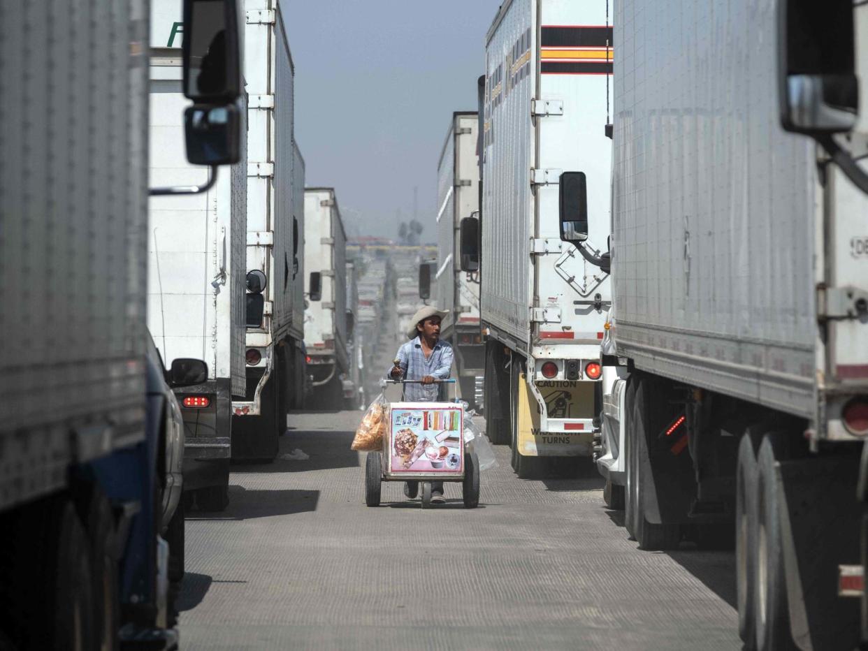 A street vendor sells ice cream to cargo trucks drivers lining up to cross to the United States at Otay commercial crossing port in Tijuana, Baja California state, on June 6, 2019: AFP via Getty Images