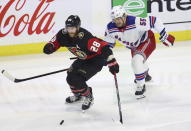 Ottawa Senators' Claude Giroux (28) and New York Rangers' Ryan Lindgren (55) chase the puck during the first period of an NHL hockey game, Wednesday, Nov. 30, 2022 in Ottawa, Ontario. (Patrick Doyle/The Canadian Press via AP)