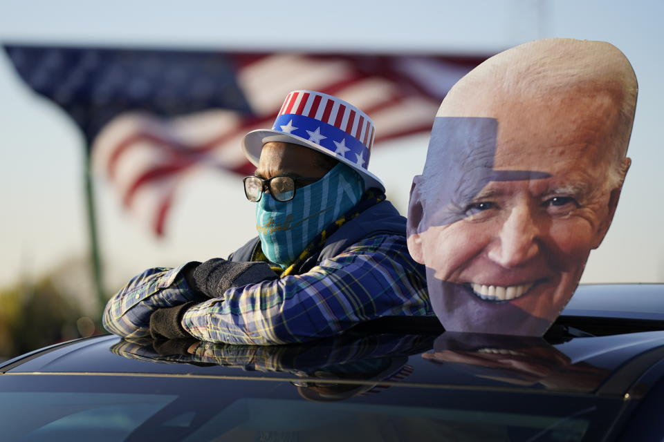 A supporter watches as Democratic presidential candidate former Vice President Joe Biden and former President Barack Obama speak at a rally at Belle Isle Casino in Detroit, Mich., Saturday, Oct. 31, 2020. (AP Photo/Andrew Harnik)