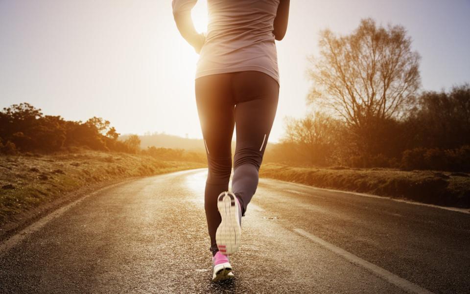 Γυναίκα με αθλητικά ρούχα τρέχει μακριά από την κάμερα και δείχνει τα αθλητικά της παπούτσια