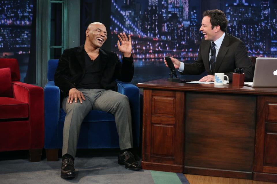 Mike Tyson laughs on stage with Jimmy Fallon.