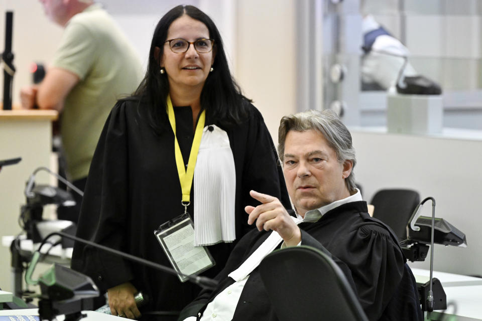 Lawyer Delphine Paci, left, speaks with Michel Bouchat, lawyer of defendant Salah Abdeslam before the reading of the sentences during the trial regarding the attacks at a Brussels metro station and the city's airport at the Justitia building in Brussels, Friday, Sept. 15, 2023. The morning rush hour attacks at Belgium's main airport and on the central commuter line took place on March 22, 2016, which killed 32 people, and nearly 900 others were wounded or suffered mental trauma. (John Thys, Pool Photo via AP)