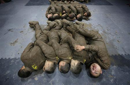 Students hold each other for warmth as they sleep during a break in between high intensity training at Tianjiao Special Guard/Security Consultant camp on the outskirts of Beijing December 1, 2013. REUTERS/Jason Lee