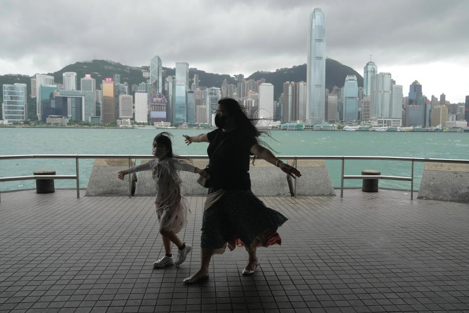 People stand by the shore as the Hong Kong Observatory raised its No.8 storm warning, in Hong Kong, Saturday, July 2, 2022. Typhoon Chaba is buffeting Hong Kong, bringing high winds and plenty of rain, but no serious damage, as of midday Saturday. (AP Photo/Kin Cheung)