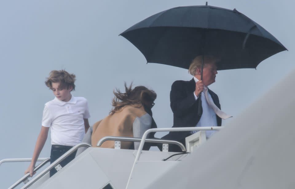 Donald Trump let Melania and Barron fend for themselves while he sheltered comfortably under a large brolly. Source: Getty