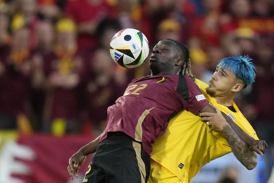 Belgium's Jeremy Doku, left, challenges for the ball with Romania's Andrei Ratiu during a Group E match between Belgium and Romania at the Euro 2024 soccer tournament in Cologne, Germany, Saturday, June 22, 2024. (AP Photo/Alessandra Tarantino)