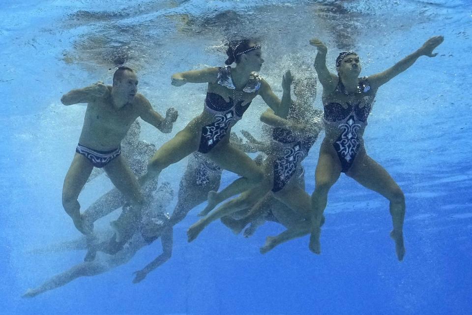 The United States, including Bill May, left, competes in the team acrobatic of artistic swimming at the World Swimming Championships in Fukuoka, Japan, Saturday, July 15, 2023. Largely unnoticed by the general public, men have been participating in artistic swimming, formerly known as synchronized swimming, for decades. (AP Photo/Nick Didlick)