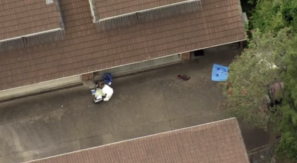 Police are seen examining the driveway.